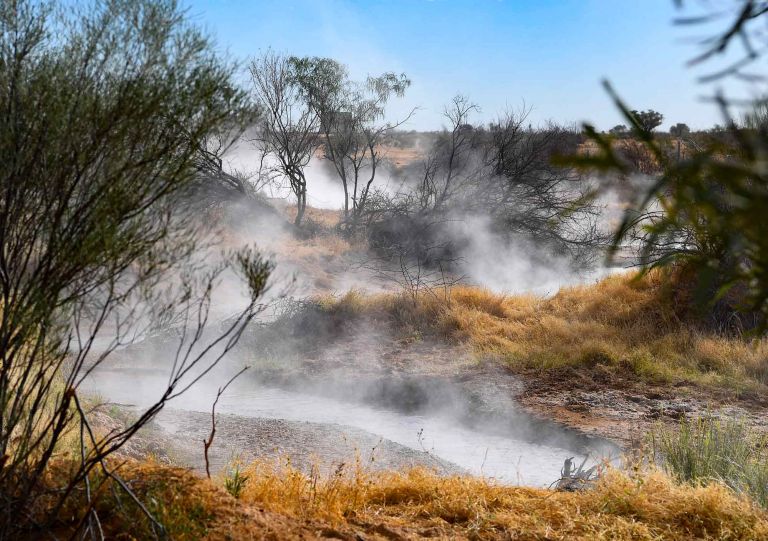 Steam rising off hot bore water which is flowing through a creek outside the queensland outback town of Birdsville