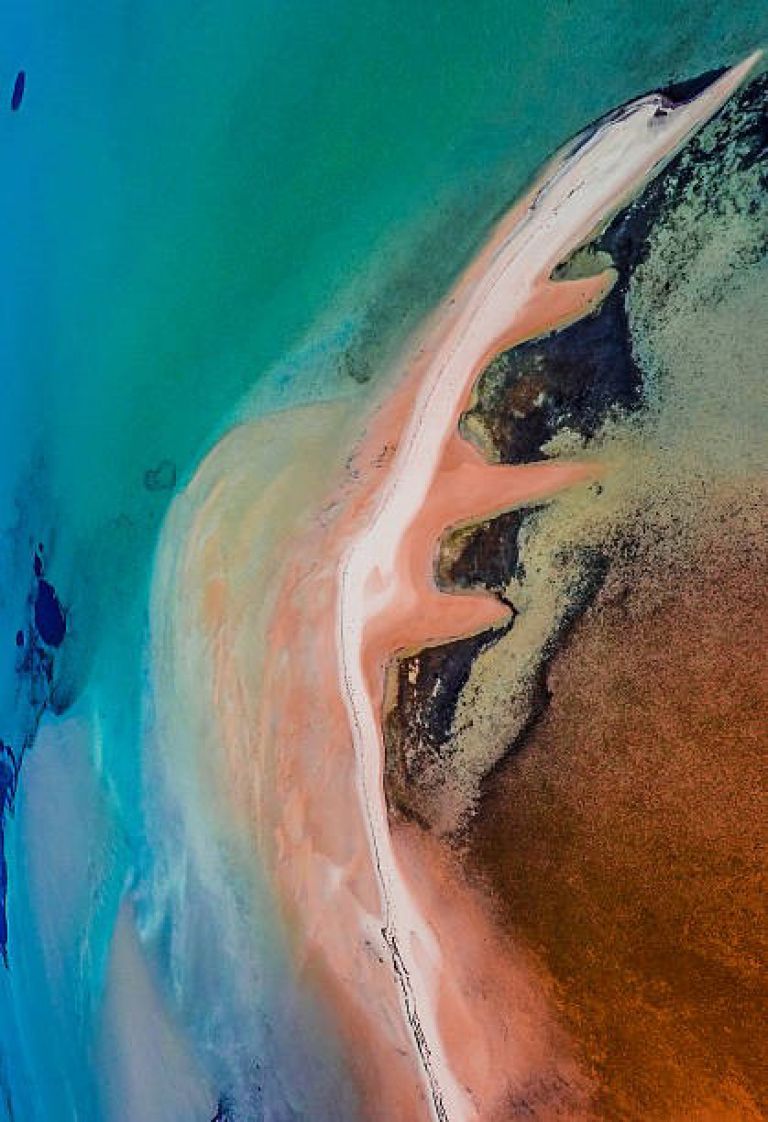 Colourful sand spit seen from aerial view through turquoise ocean