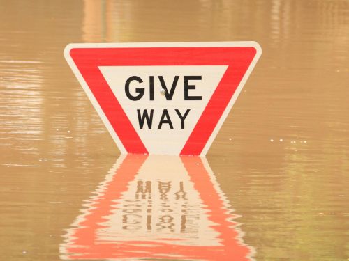 Give way sign submerged in floodwater