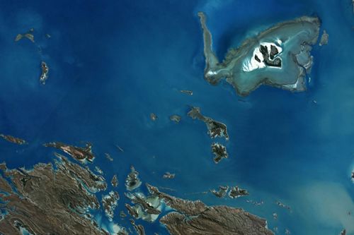 satellite image of coast and water showing protruding sandy island