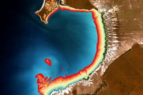 red, yellow and blue illustrated overlay along curved coastline image as captured by satellite